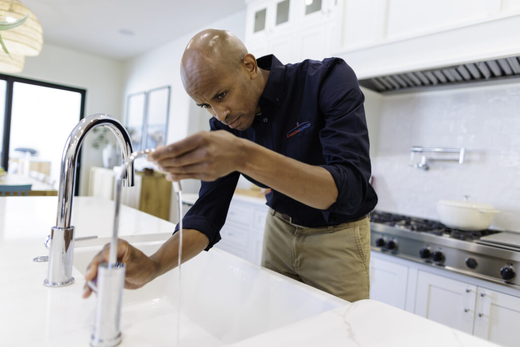 home inspector testing a kitchen sink faucet
